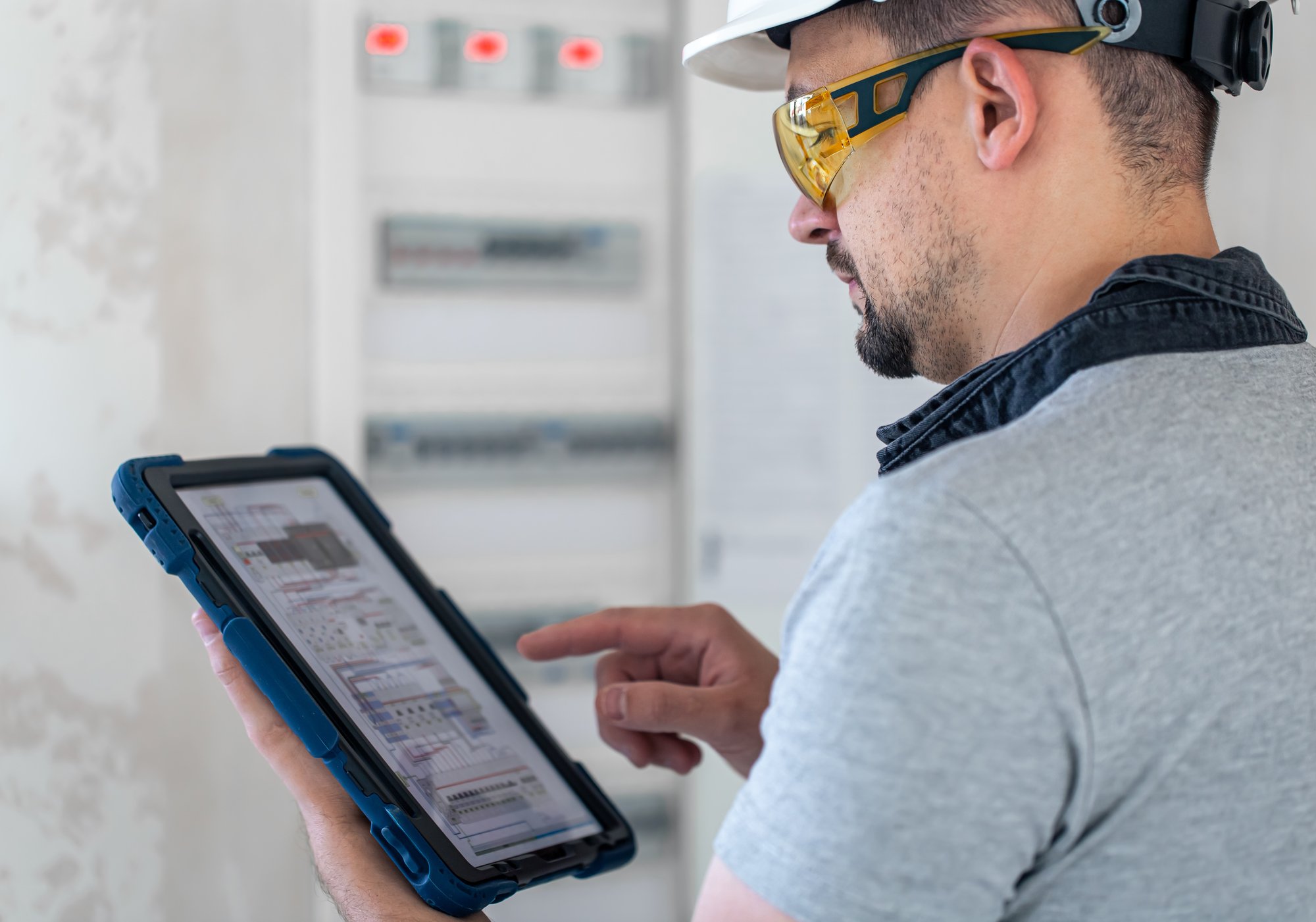 electrical-technician-looking-focused-while-working-switchboard-with-fuses