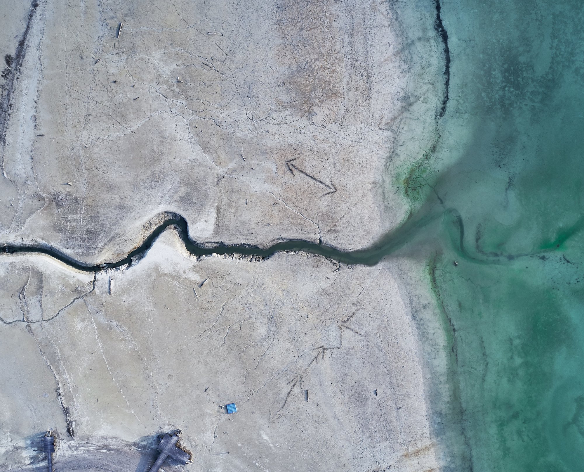 high-angle-shot-big-crack-stony-shore-turquoise-water